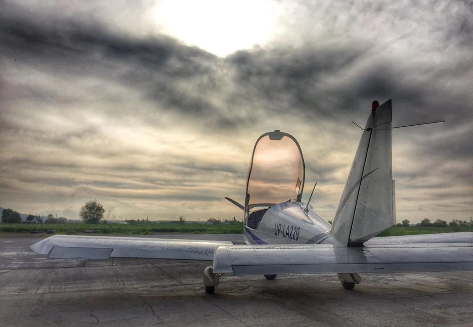 Small charter plane on the tarmac under a dramatic cloudy sky